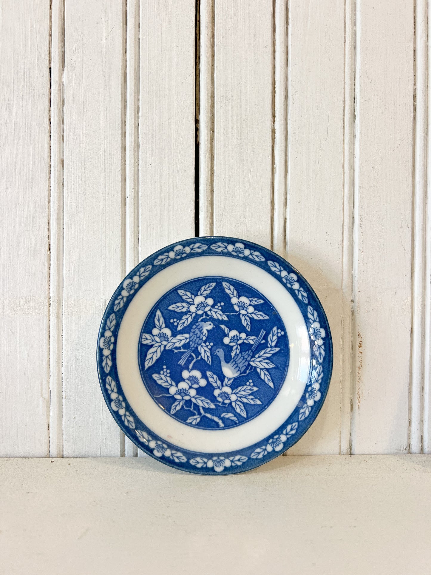 Vintage 4.75 inch blue and white ceramic bird plate with floral border