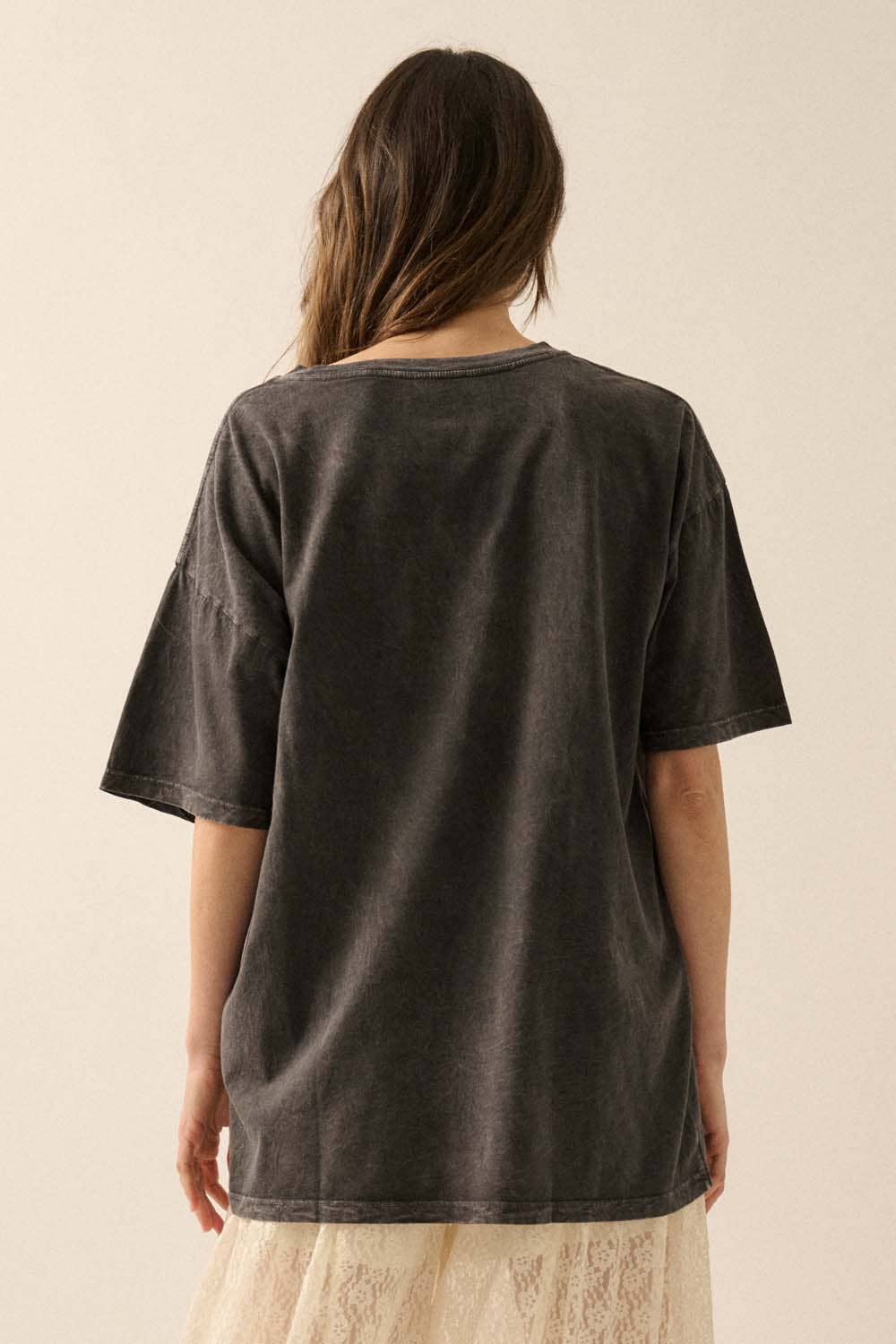 Person wearing a dark gray t-shirt against a beige background