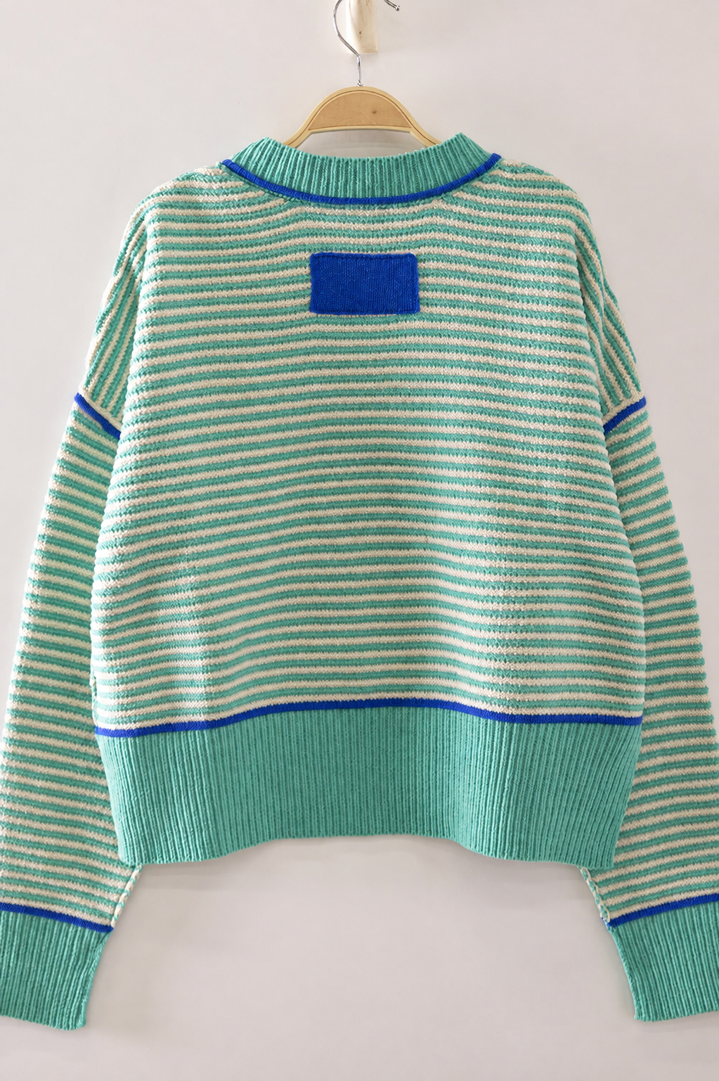 Back view of The Good Company Stripe Sweater in Sea Glass featuring aqua stripes, cobalt contrast stitching, and a blue knit patch detail.