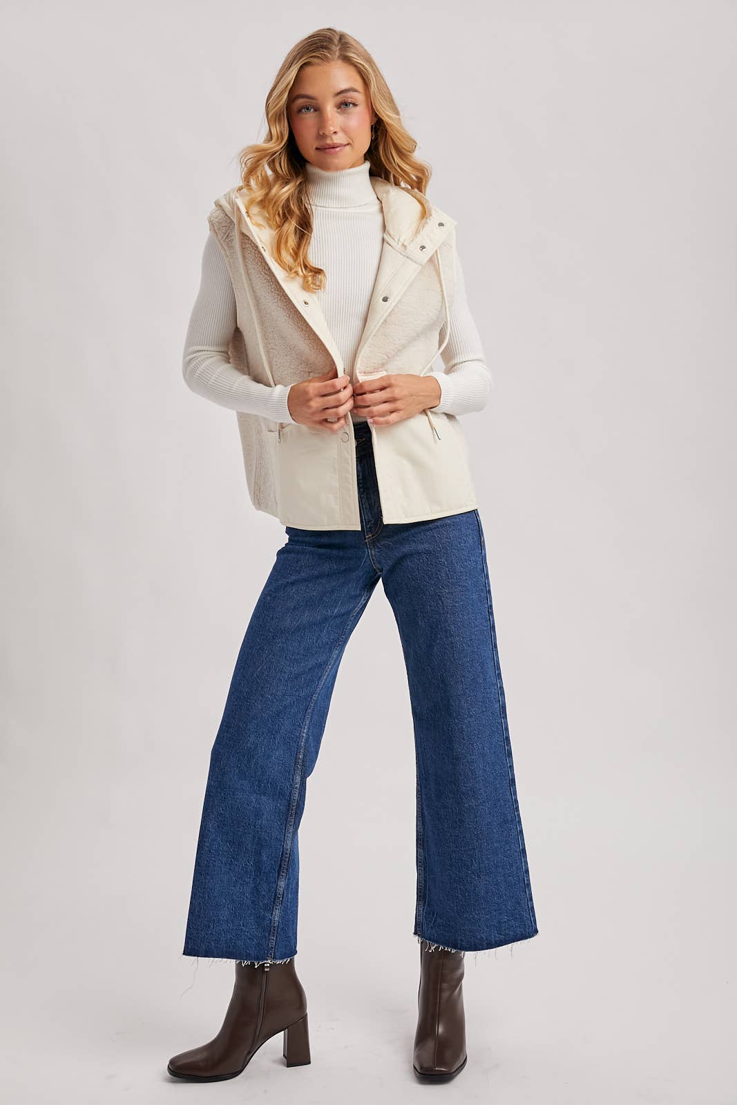 Full outfit view of ivory sherpa vest with jeans and ankle boots