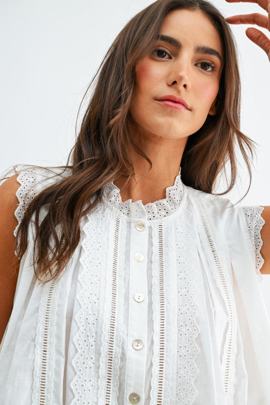 Woman wearing a white lace blouse against a plain background