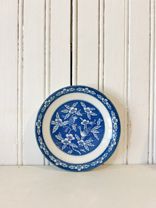 Vintage 4.75 inch blue and white ceramic bird plate with floral border

