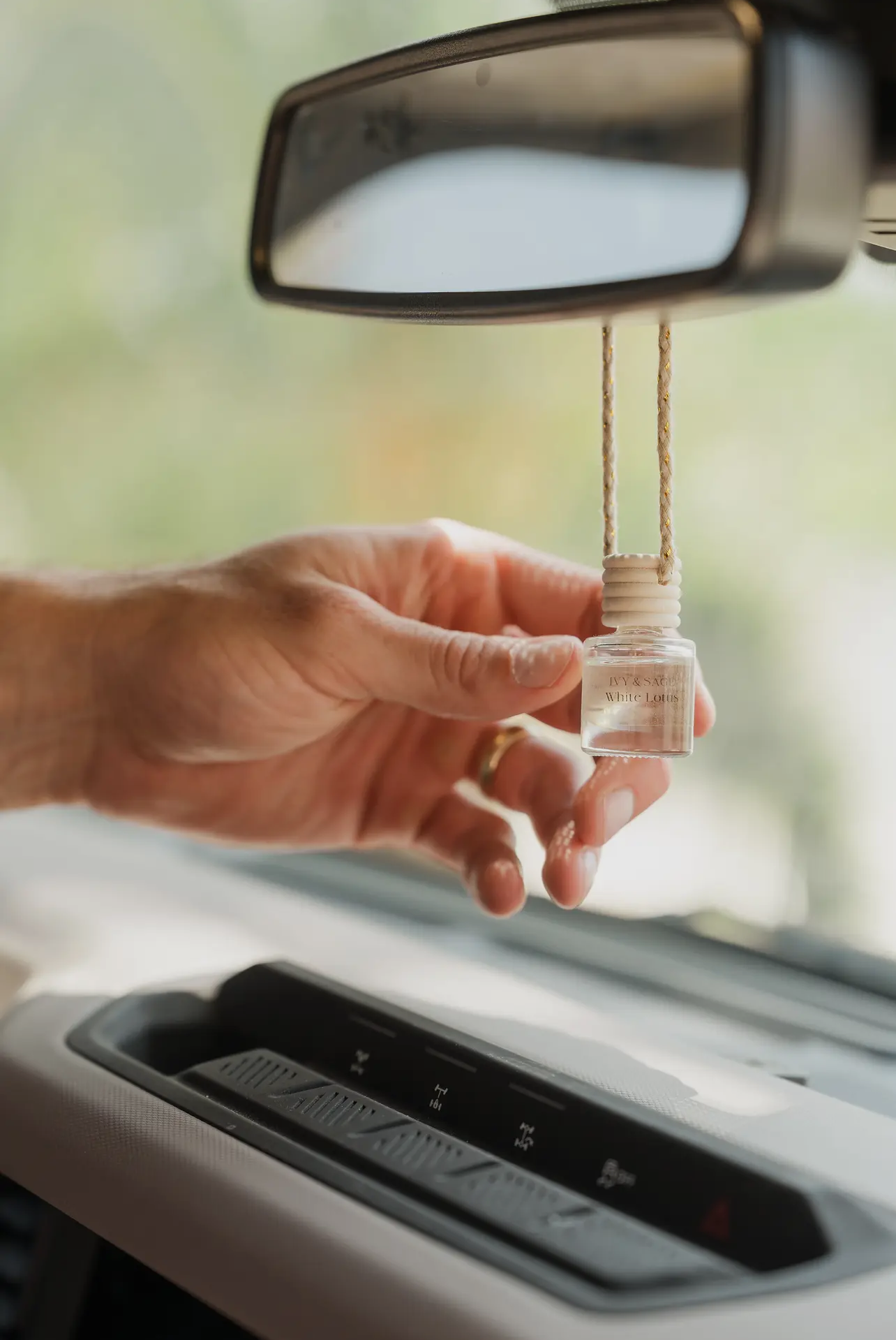 Smoked Vanilla car diffuser hanging from rearview mirror