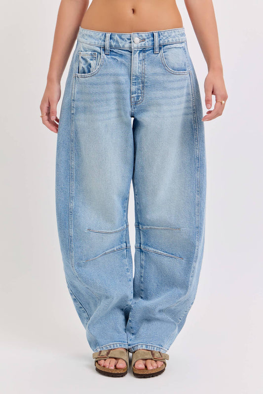 Light blue barrel jeans worn by a person on a white background