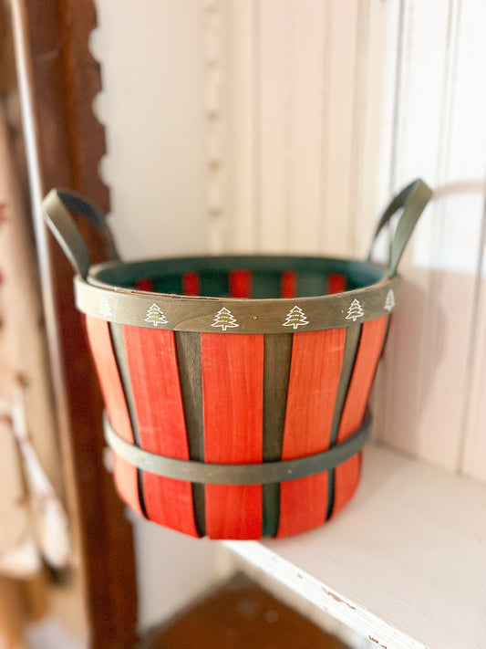Vintage red and green wooden Christmas basket with tiny white tree accents along the rim.