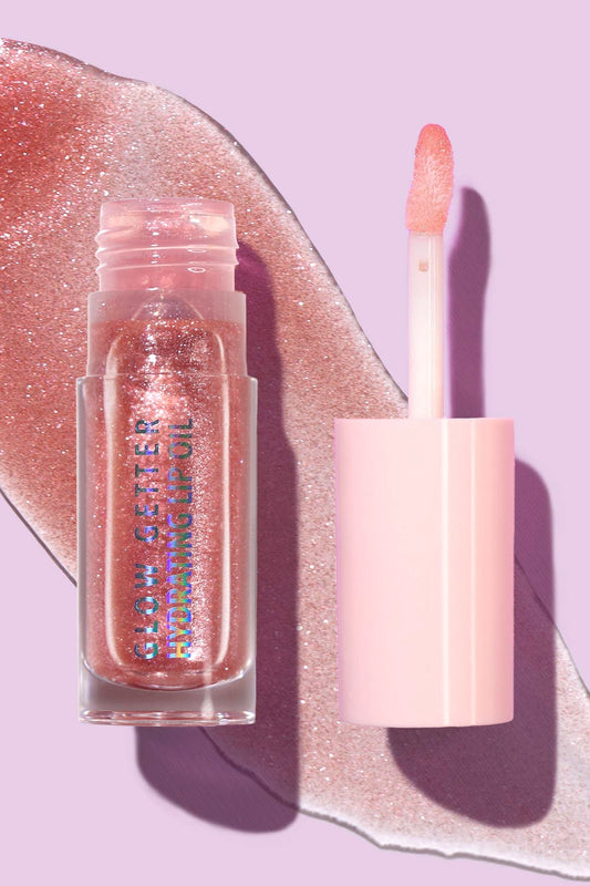 Lip gloss and lip balm on a glittery pink background