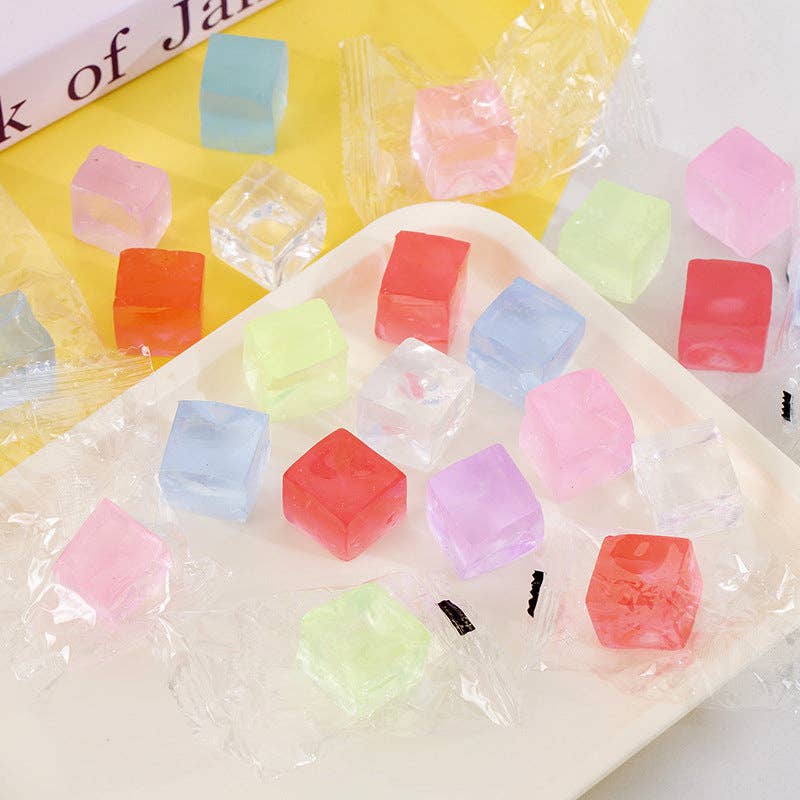 Colorful cube-shaped squishies on a white plate with a yellow background
