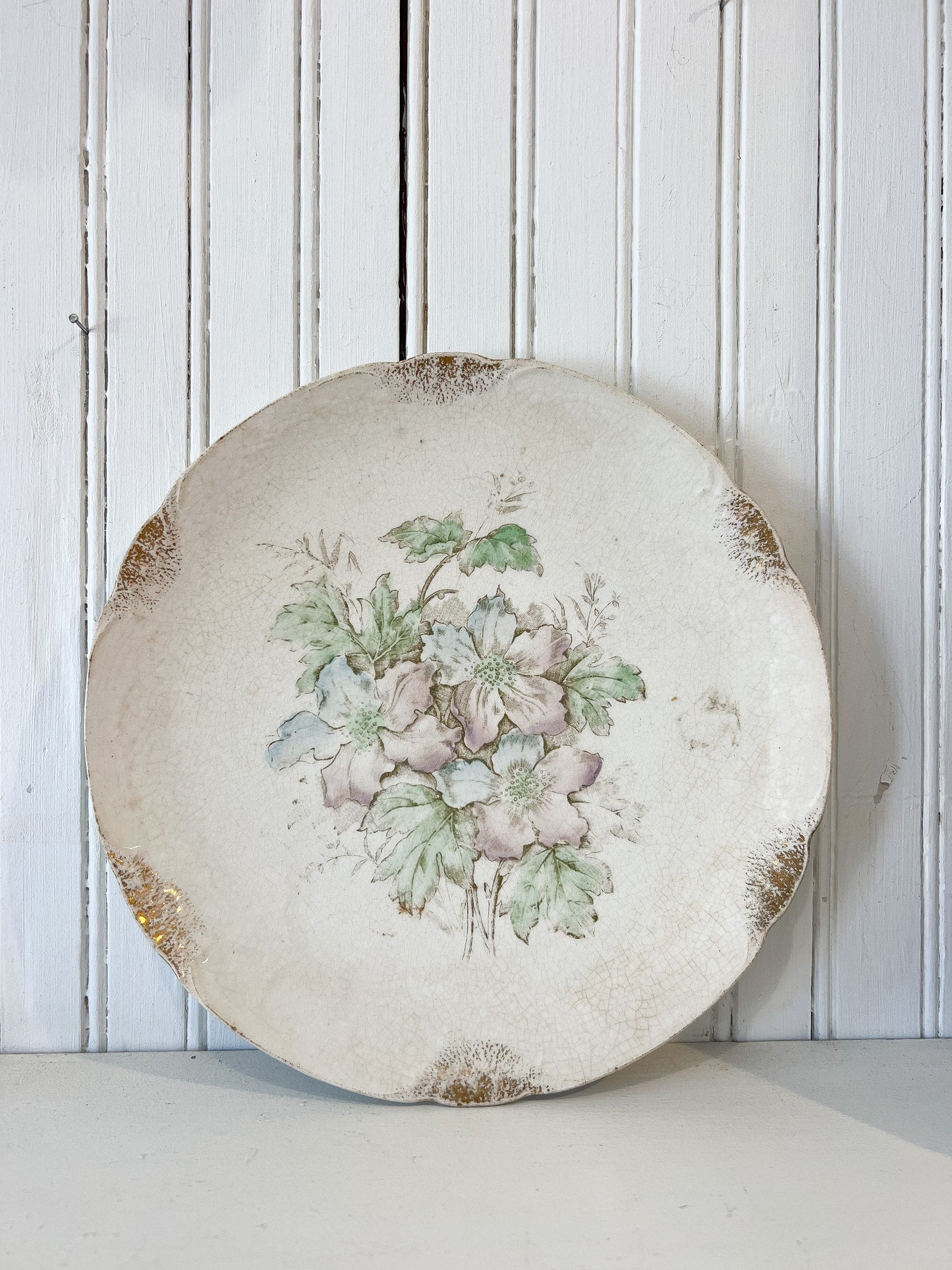 Decorative plate with floral design on a white wooden panel background
