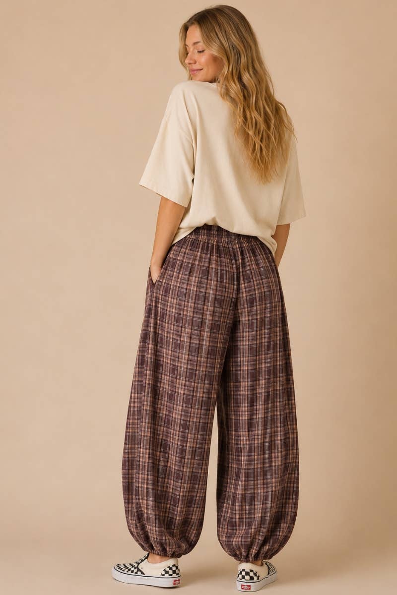 Woman wearing plaid pants and a beige top on a beige background
