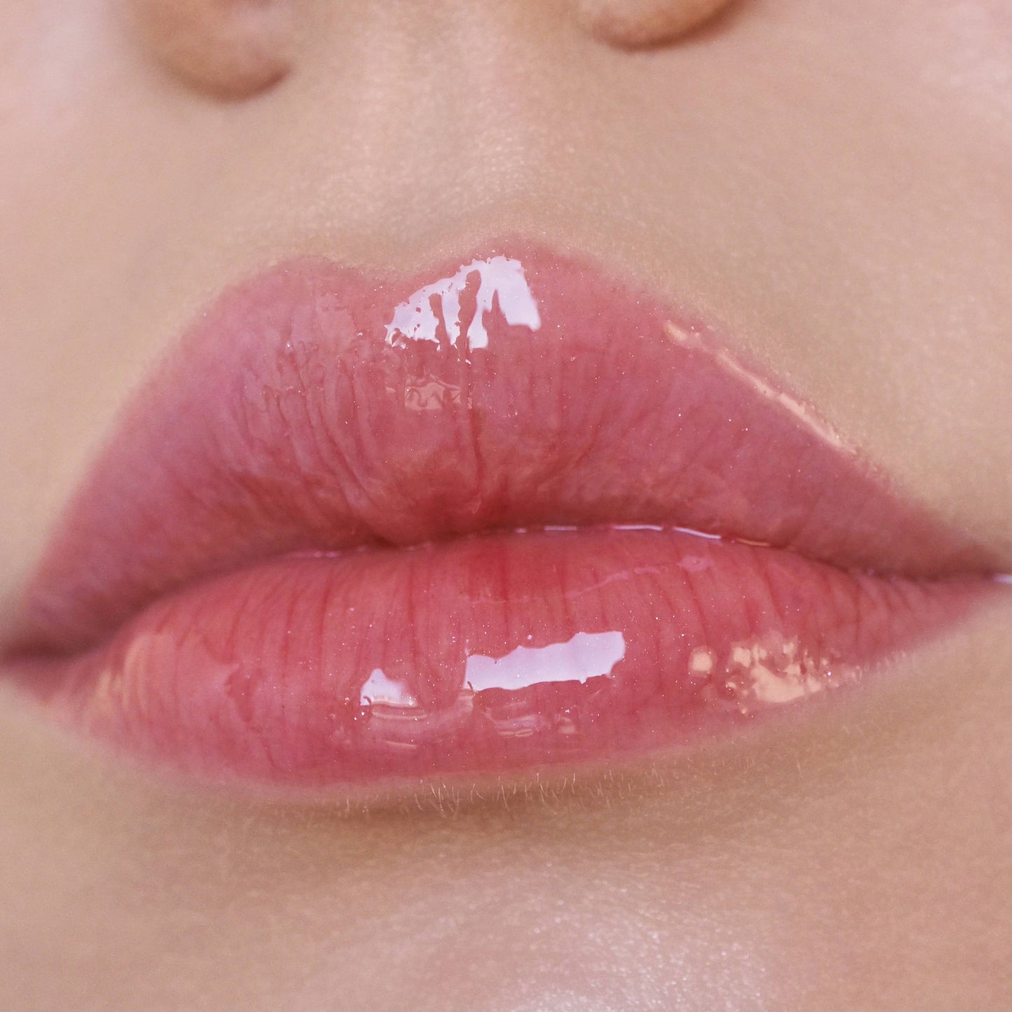 Close-up of glossy pink lips with a blurred background