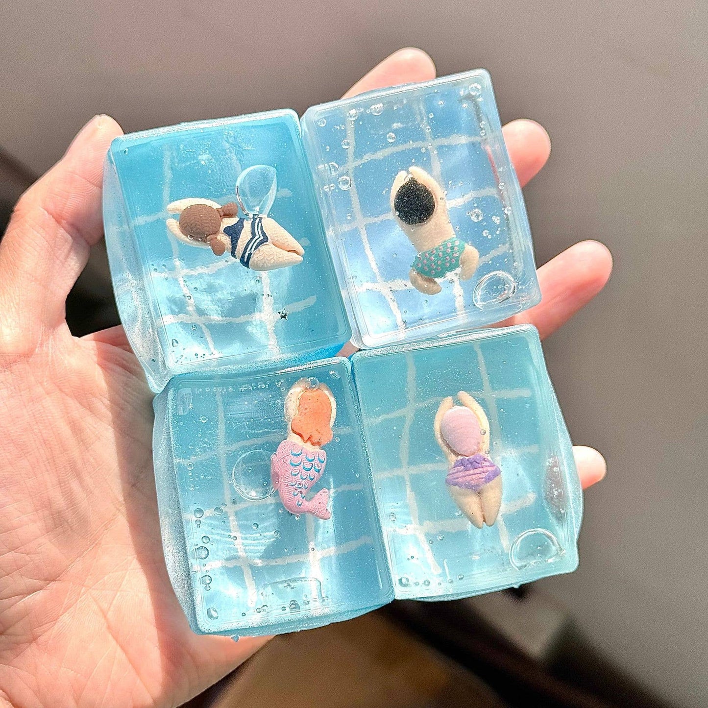 Blue summer pool themed squishy toy with tiny floating figures inside