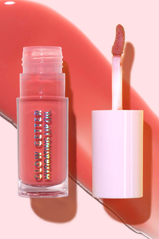 Lip gloss with applicator on a pink background