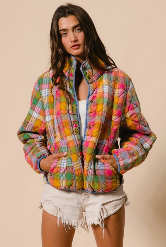 Woman wearing a colorful plaid jacket on a beige background