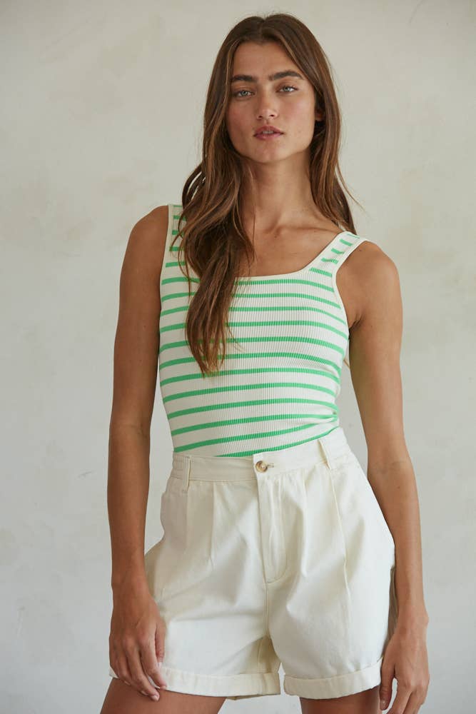Woman wearing an ivory and key lime striped seamless ribbed square neck bodysuit paired with white cuffed shorts.