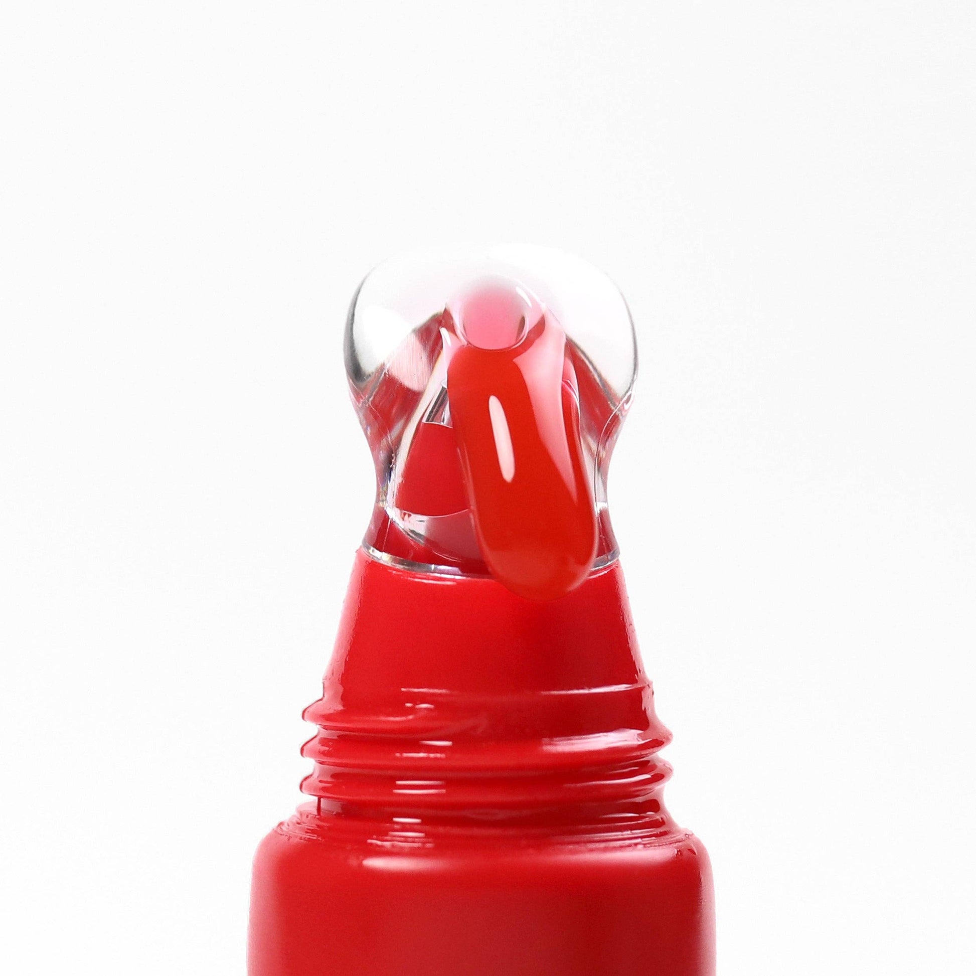 Red nail polish bottle with clear cap on a white background