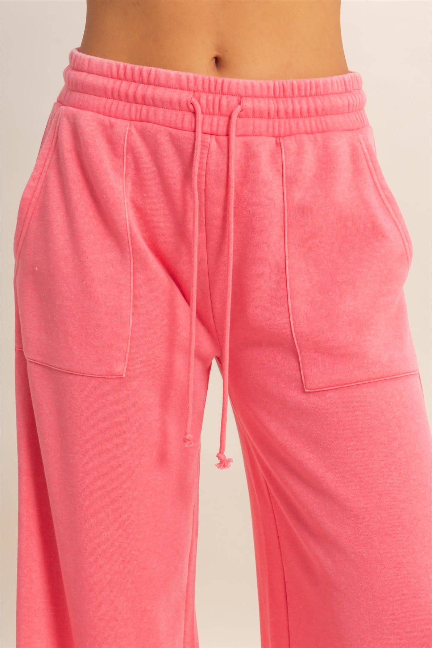 Pink sweatpants with a drawstring on a light background