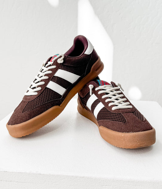 Side angle of mocha brown vintage-inspired sneakers with white stripes and gum soles on a white background.
