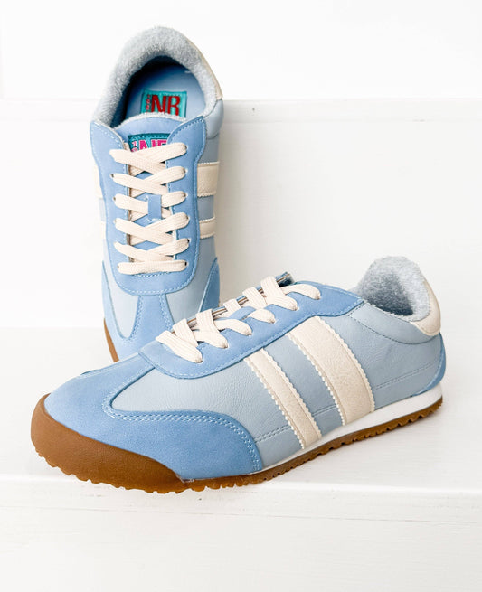 Pair of powder blue and cream retro runner sneakers with gum soles styled on a clean white background.