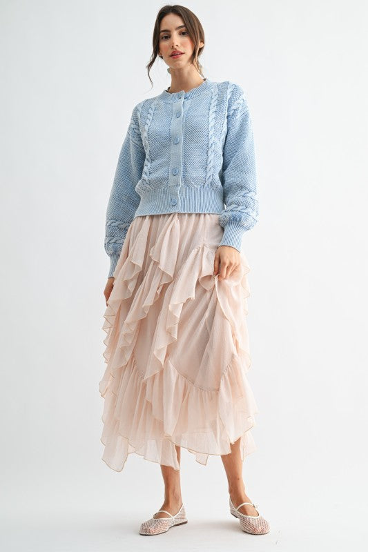 Woman wearing a light blue top and beige ruffled skirt on a white background