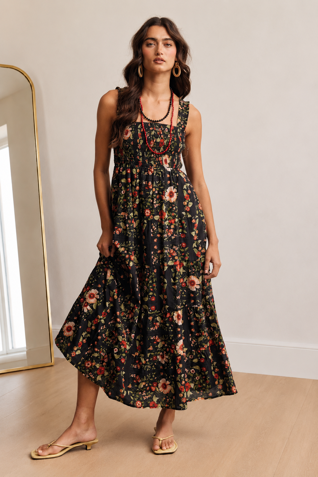 Front view of The Folk Tale black floral cotton maxi dress with a smocked bodice and tiered skirt