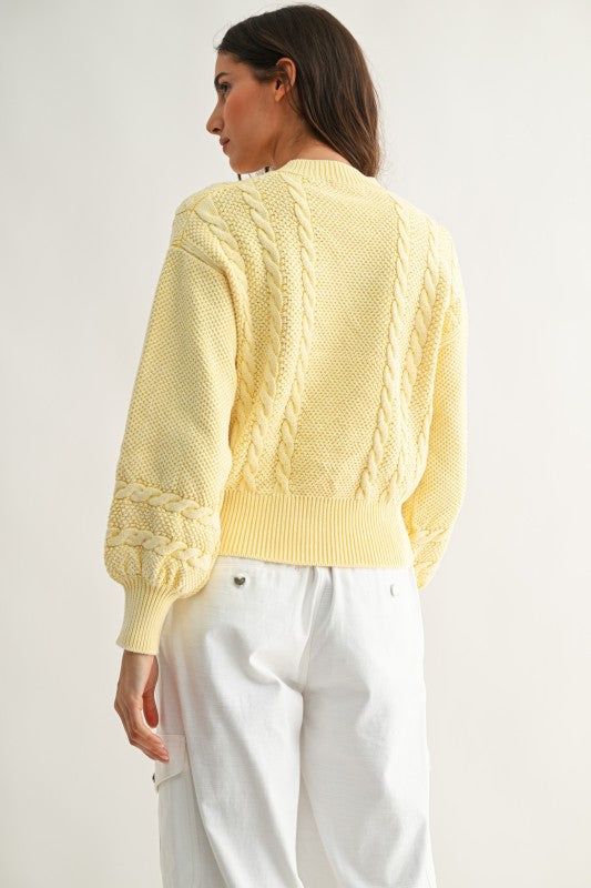 Back view of textured cable knit cardigan in sweet cream yellow