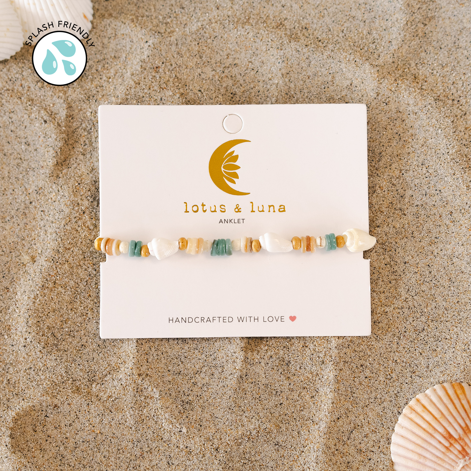 Beaded anklet on a 'lotus & luna' branded card with seashells on a sandy background