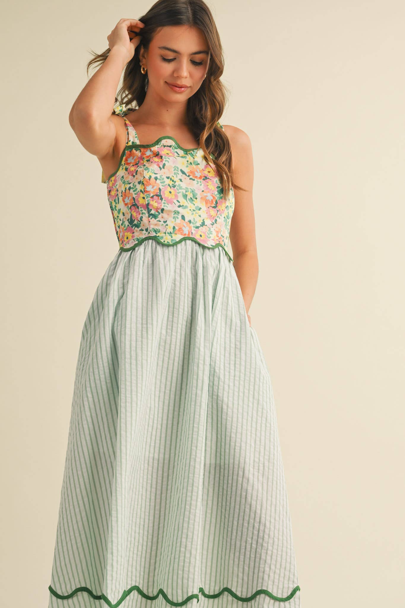 Woman wearing a floral top and striped skirt on a beige background