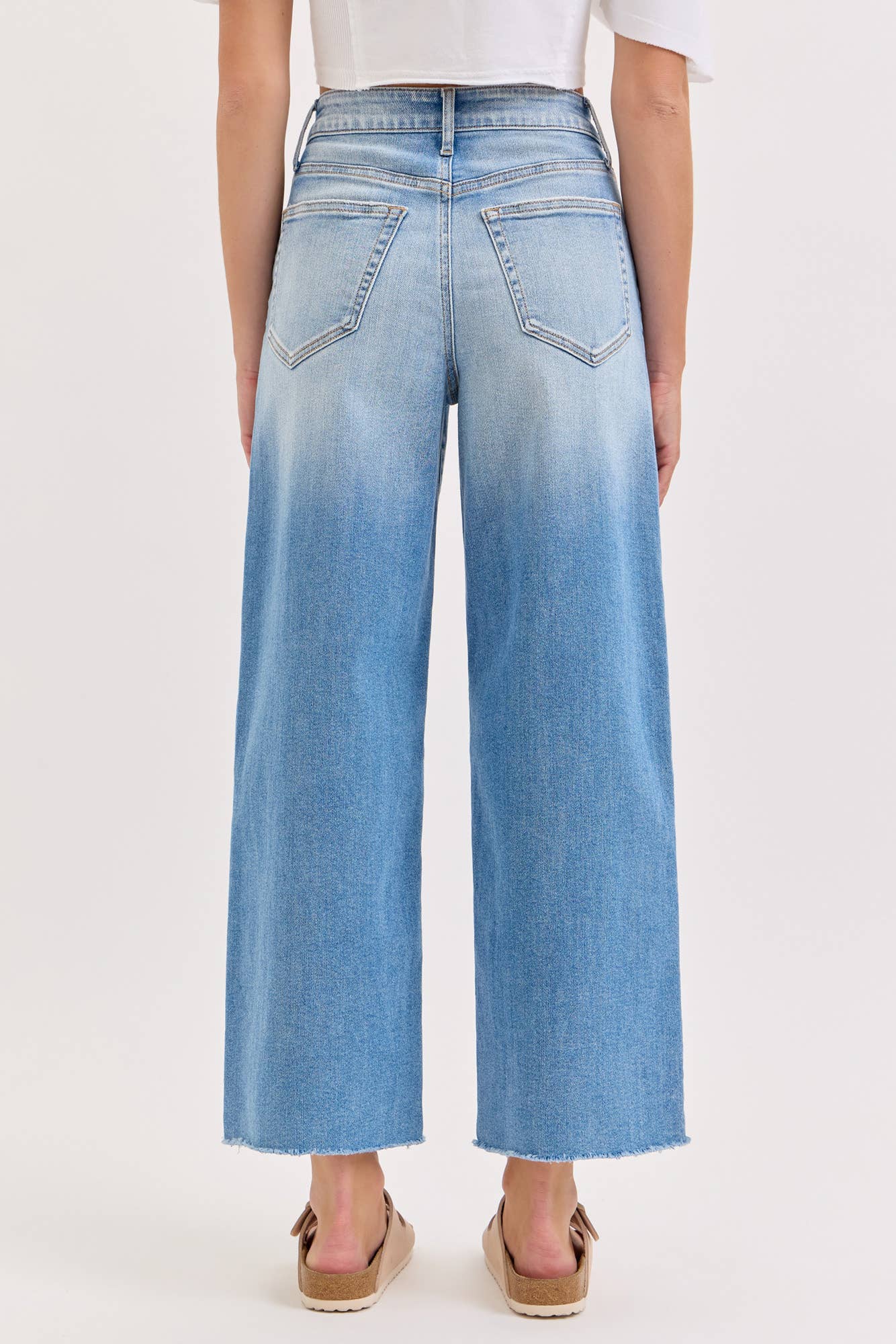 Light blue jeans worn by a person on a white background