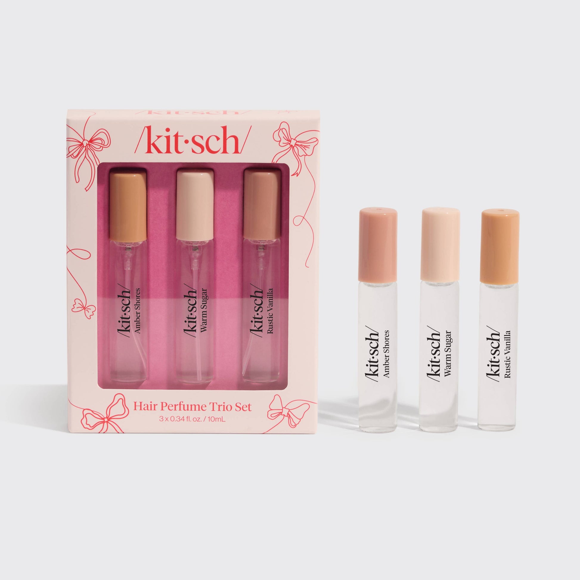 Kitsch Hair Perfume Trio Gift Set with three mini bottles—Amber Shores, Warm Sugar, and Rustic Vanilla—in a pink box with bow design.
