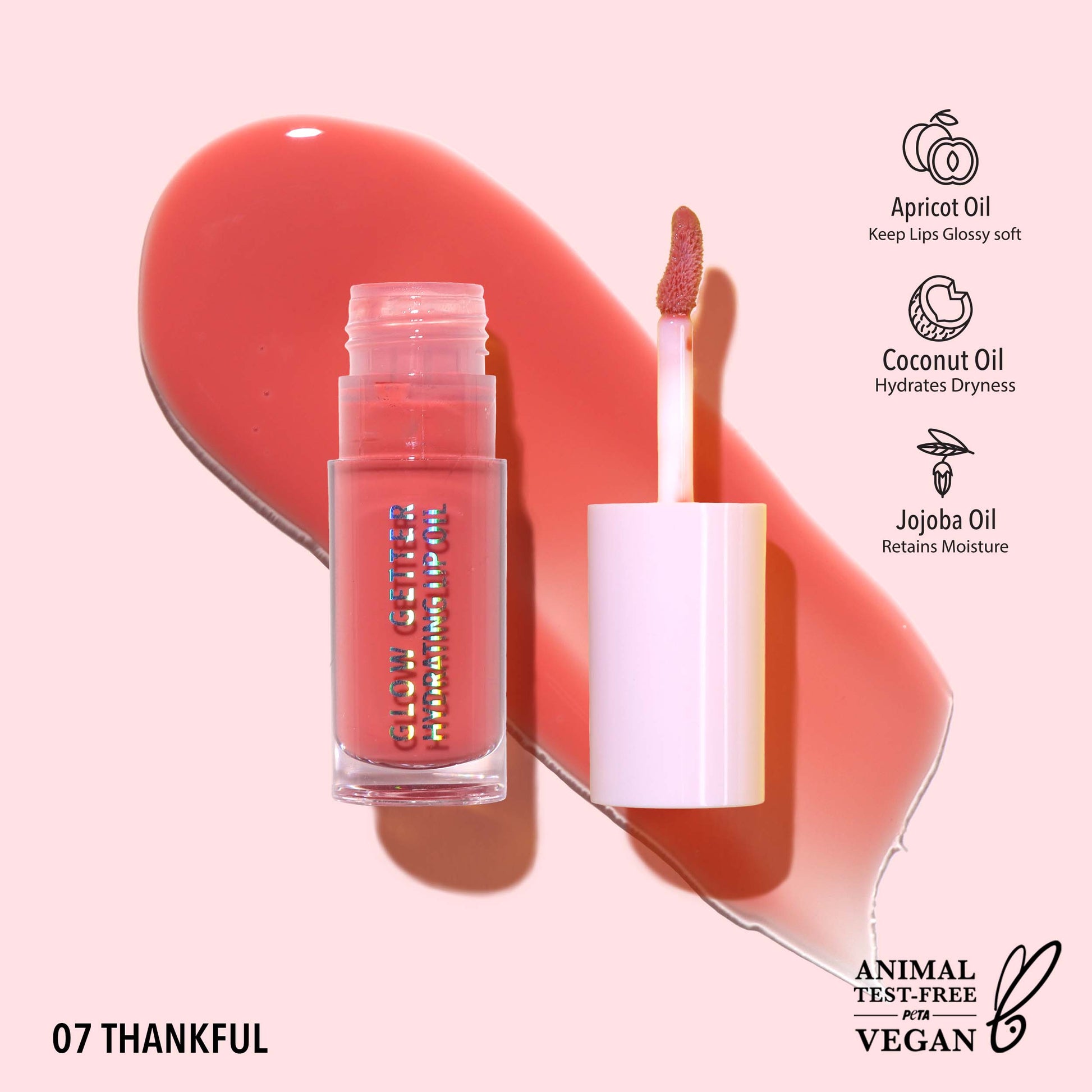 MOIRA Glow Getter Hydrating Lip Oil in Thankful with sheer warm coral tint and glass-like glossy finish in clear tube packaging.
