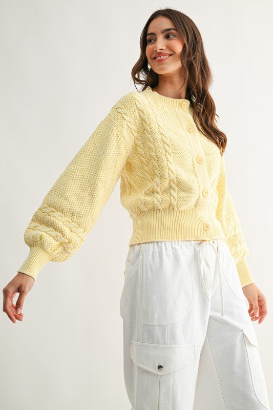 Women’s sweet cream cable knit cardigan styled with white cargo pants