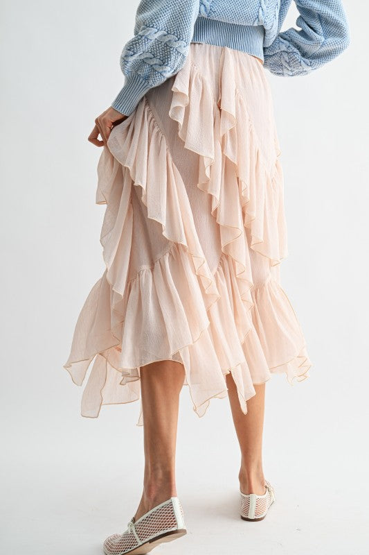 Person wearing a light blue sweater and beige ruffled skirt on a white background