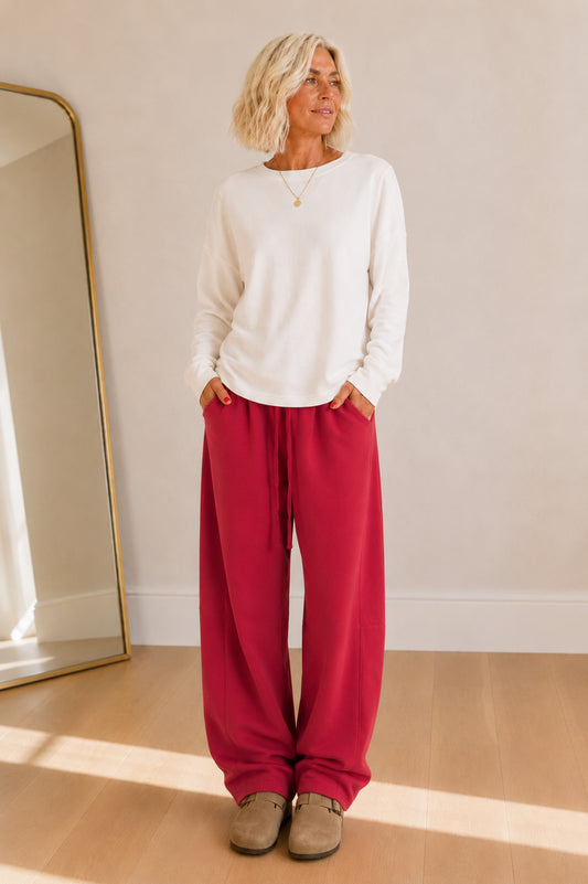 Rich cranberry barrel-leg sweatpants featuring an elastic waist and ultra-soft fabric.