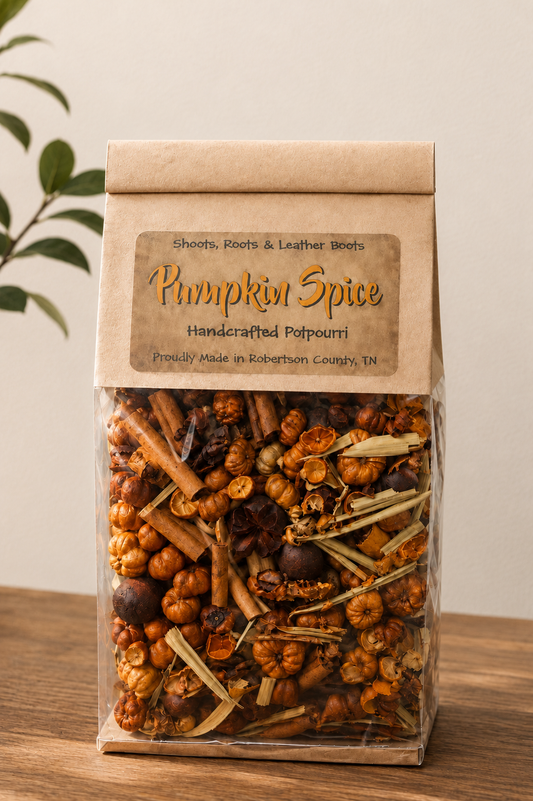 A clear plastic bag of Pumpkin Spice handcrafted potpourri with a brown kraft paper label, sitting on a wooden surface against a neutral beige background.