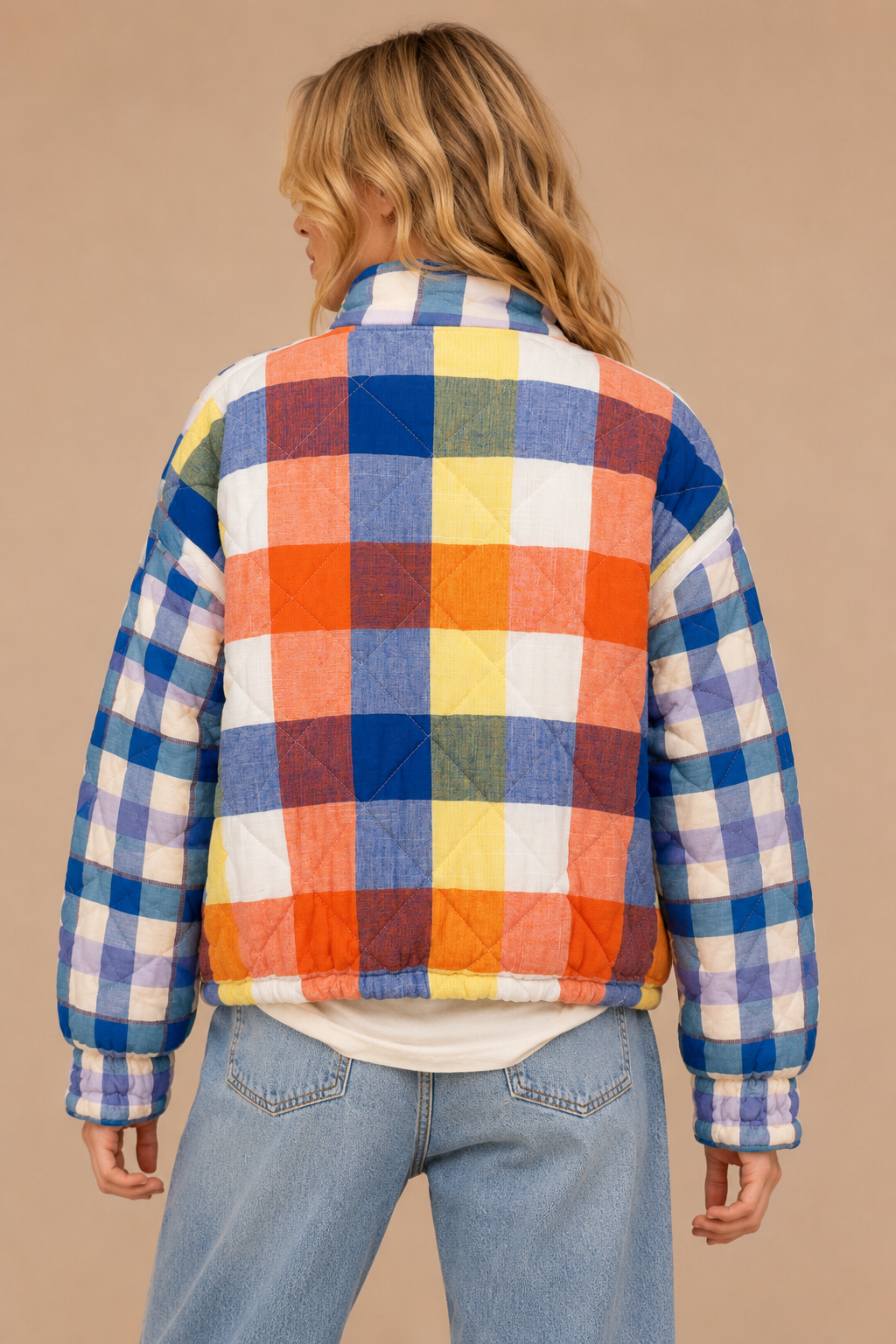 Back view of a colorful mixed-plaid quilted jacket with a relaxed fit and elasticized hem.