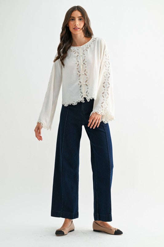 Ivory embroidered lace blouse featuring fabric-covered buttons and delicate scalloped trim at neckline