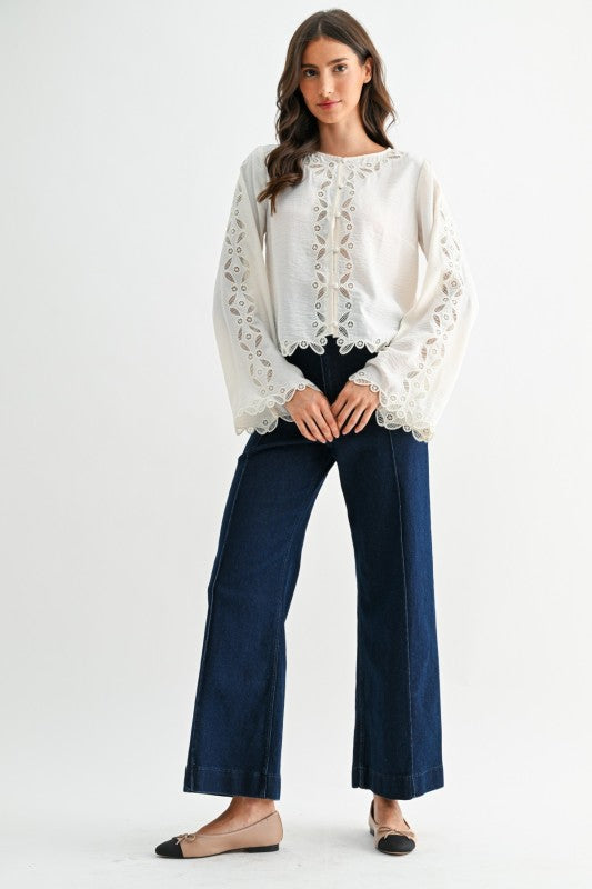 Ivory long sleeve blouse with intricate scalloped lace embroidery along the sleeve and cuff