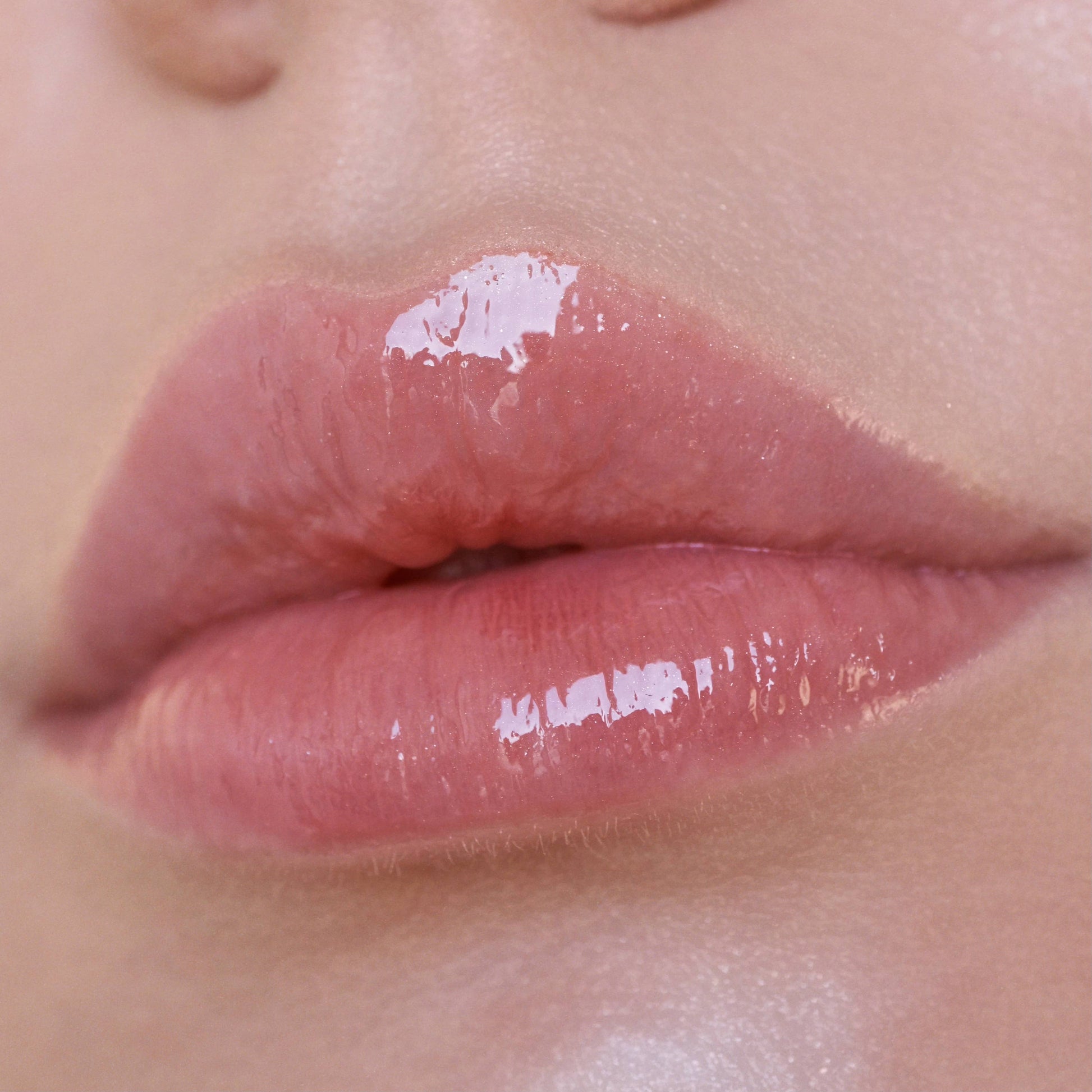 Close-up of glossy pink lips with a blurred background