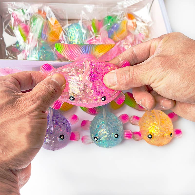 Colorful fish-shaped squishies held by hands with a clear plastic bag of more squishies in the background.