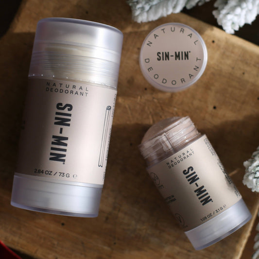 SIN-MIN Sweet Cinnamon and Vanilla aluminum-free natural deodorant in full and travel size on wood surface
